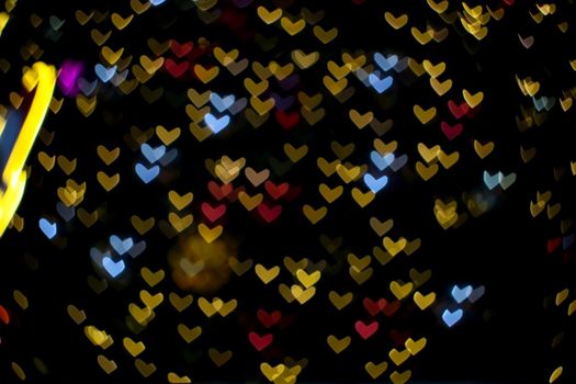 colorful abstract bokeh and blur heart shape love valentine night light on wall at shopping mall