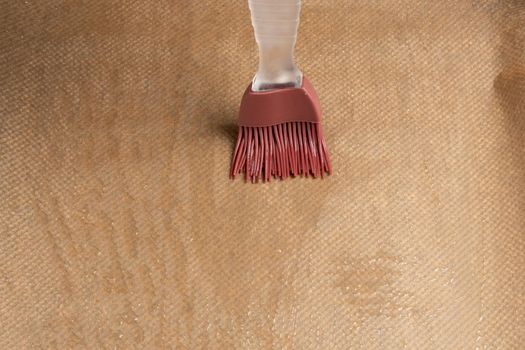 Greasing a baking sheet covered with baking paper.