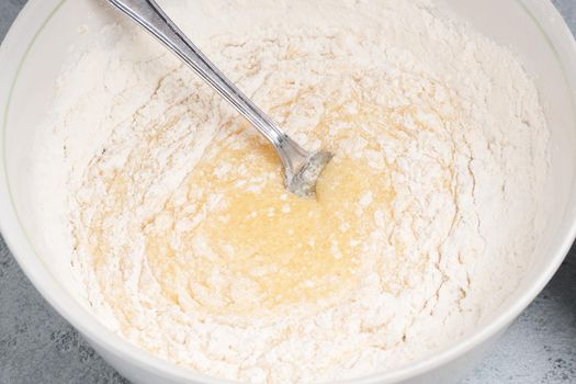 Making homemade pie dough. Mixing ingredients in a bowl.