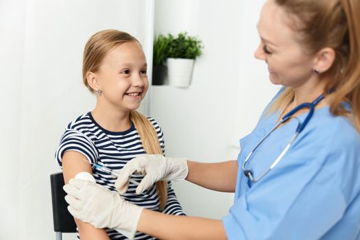 woman doctor injections in the arm of a child in the hospital health care. High quality photo