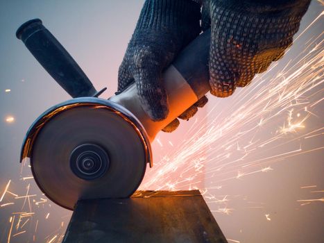 Sawing metal with circular saw sparks close up