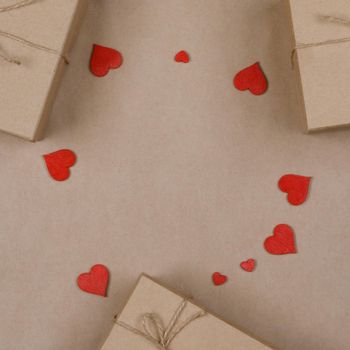 Boxes with gifts wrapped in brown craft paper and red paper hearts Valentines day concept