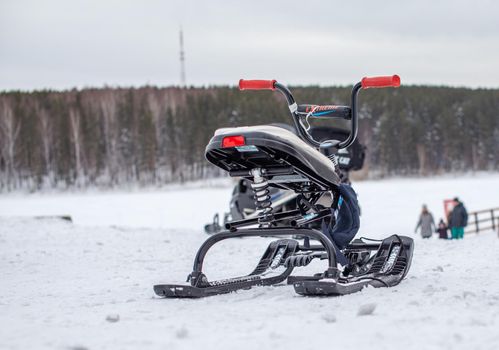 The children's snowmobile is ready for children to ride. Entertainment activities for children riding in the snow in winter