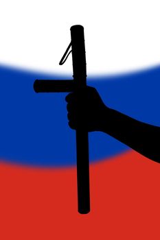hand with police tonfa rubber stick silhouette and blurry russian flag in the background - violent riot control concept