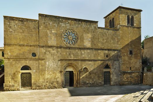 TUSCANIA-iTALY-August  2020- tuff facade of Santa Maria della Rosa church  ,simple facade with three ports ,beautiful rose window and a small bell tower