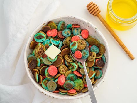 Trendy food - pancake cereal. Heap of colorful mini cereal pancakes. Tiny pancakes with natural color - green matcha, turquose spirulina, blue pea, red fragon fruit