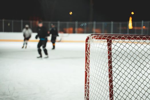 People play hockey outdoors in winter time.