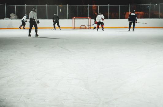 People play hockey outdoors in winter time.