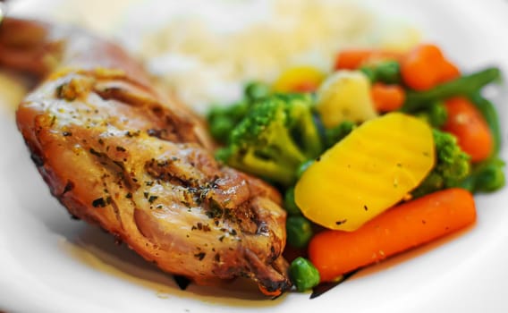 Baked rabbit leg with rice and vegetables.