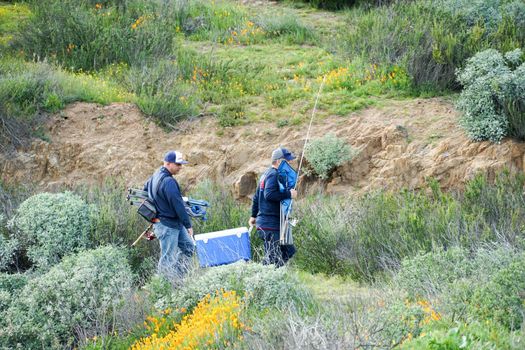 Two fisher-mans walking in the valley to the lake. Diamond Valley Lake. One of the largest reservoirs in Southern California. USA. January 16th, 2021