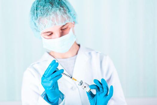 Woman doctor or nurse in uniform and gloves wearing face mask protective in lab holding medicine vial vaccine bottle with COVID-19 Coronovirus vaccine label