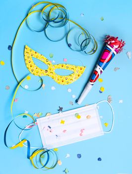 masks, confetti, treamers and mask on a colorful carnival table during Covid 19 pandemic