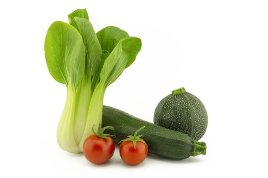 Fresh pak choi cabbage green round and traditional courgette or zucchini and cherry tomato isolated on white background