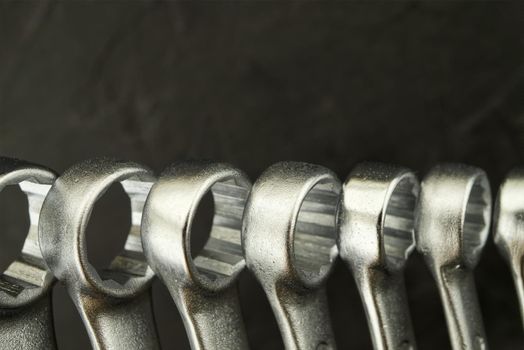 Set of spanners or wrenches in close up over a grunge stone background with free copy space