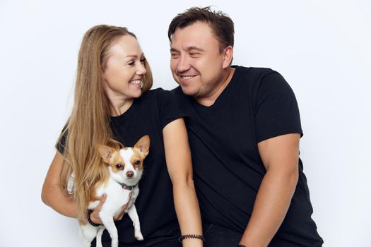 married couple in black t-shirts little dog joy. High quality photo