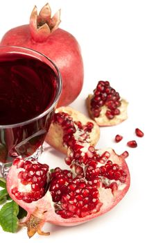 Garnet juice in a glass and pomegranate on the white