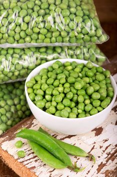 fresh green pea in bowl on wooden background.