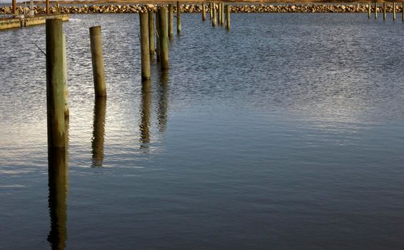Pier columns at a calm sea inside the harbor with copy space