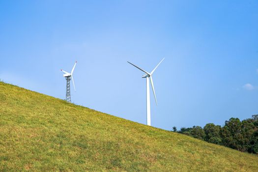 Wind power station. Wind generators stand in agricultural fields on mountain. Wonderful landscape shot from a great height. Modern green energy.