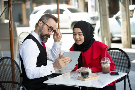 Business people talking in office using digital tablet and social media technology for communication.