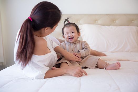 Loving and affectionate mother holding newborn baby indoors at home.