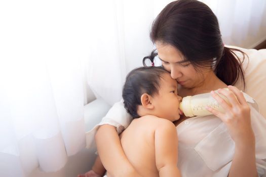 Loving and affectionate mother holding newborn baby indoors at home.