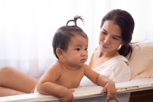 Loving and affectionate mother holding newborn baby indoors at home.