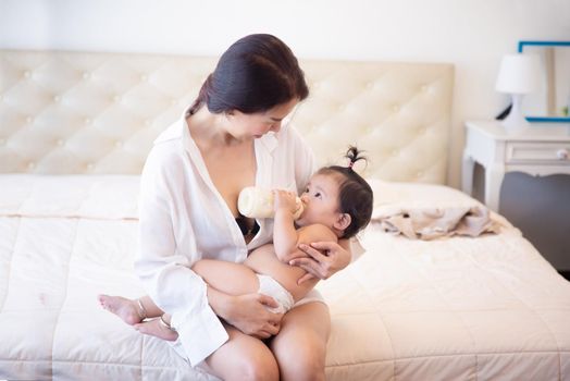 Loving and affectionate mother holding newborn baby indoors at home.