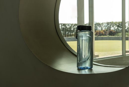 Sport water bottle in sport club or gym and fitness room with free space. Gym concept. Selective focus.