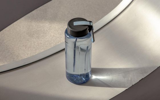 Sport water bottle in sport club or gym and fitness room with free space. Gym concept. Selective focus.