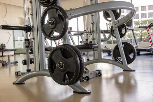 Within gym or fitness studio with modern fitness equipment for fitness events and more. Modern of gym interior with equipment. Sports equipment in the gym. Selective focus.