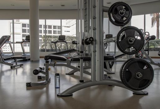 Within gym or fitness studio with modern fitness equipment for fitness events and more. Modern of gym interior with equipment. Sports equipment in the gym. Selective focus.