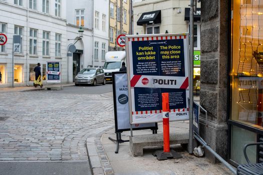 Copenhagen, Denmark - November 5, 2020: Police warning sign in the city centre reminding people not to form groups and to keep distance due to corona virus.