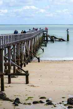 NOIRMOUTIER, FRANCE - CIRCA SEPTEMBER 2015: People walk and fish on the pier on Plage des Dames.