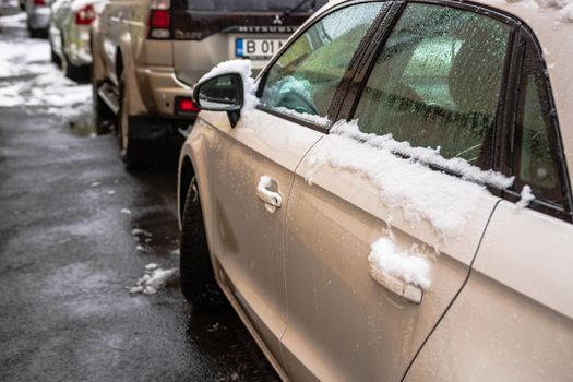 Snow on cars in the morning. Winter season, icy cars. Winter concept, frozen cars on the road in Bucharest, Romania, 2021