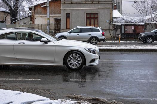 Snow on cars in the morning. Winter season, icy cars. Winter concept, frozen cars on the road in Bucharest, Romania, 2021