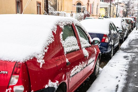 Snow on cars in the morning. Winter season, icy cars. Winter concept, frozen cars on the road in Bucharest, Romania, 2021