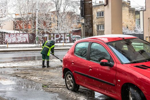 Snow removal, worker cleaning the snowy road in Bucharest, Romania, 2021