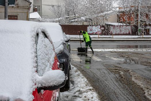 Snow removal, worker cleaning the snowy road in Bucharest, Romania, 2021