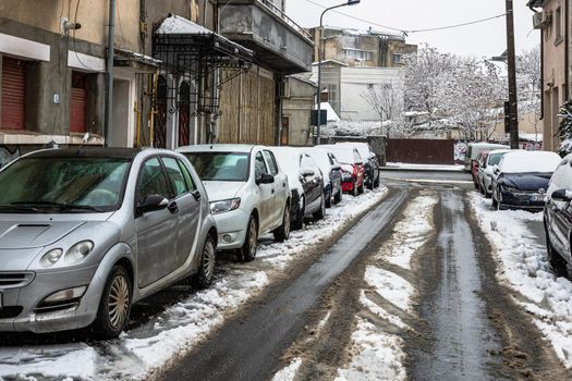 Snow on cars in the morning. Winter season, icy cars. Winter concept, frozen cars on the road in Bucharest, Romania, 2021