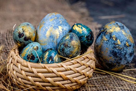 Easter decoration concept: blue painted eggs in a basket close-up on dark background. Spring religious holidays.