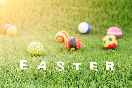 Easter bunny toy and Easter eggs on green grass with text