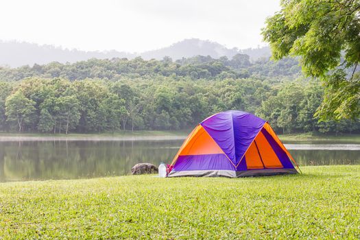 Tourist dome tent camping in forest camping site at lake side