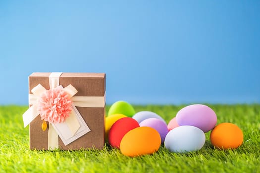 Close up Colorful easter eggs on green grass and gift box