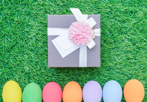 Close up Colorful easter eggs on green grass and gift box