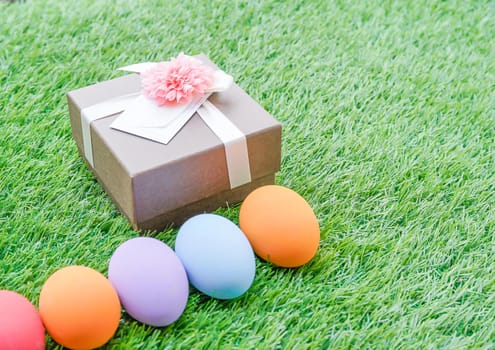 Close up Colorful easter eggs on green grass and gift box