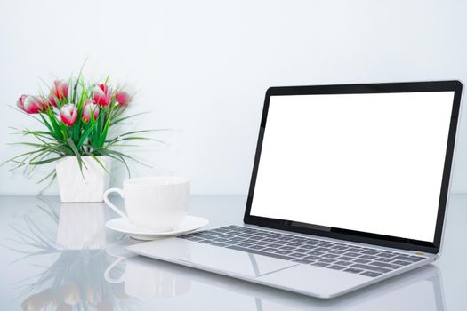 Laptop mockup with blank screen and book and flower on table