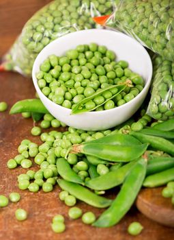 fresh green pea in bowl on wooden background.