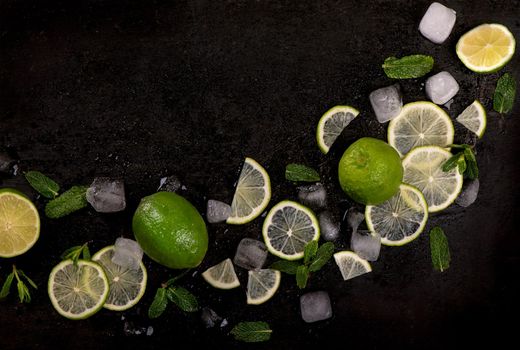 Fresh mint, lime and ice on a black background. Ingredient for mahito. Top view