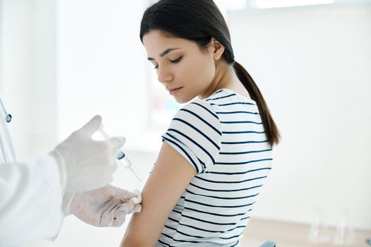 woman in medical mask vaccination in hospital health protection. High quality photo